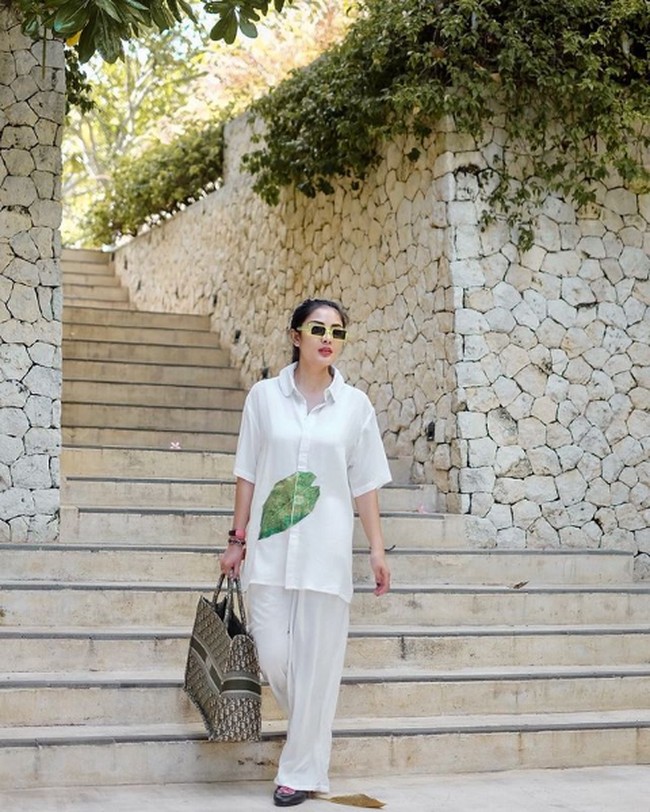 Dari gaya glamor, beralih ke busana casual tapi tetap stylish. Penyanyi 32 tahun ini tampil monokrom dengan setelan kemeja dan celana longgar berwarna putih. Foto: Instagram/@mozawahyu, @nindyparasadyharsono