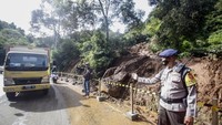Petugas menjaga sekitar lokasi longsor di jalan utama Puncak, Gunung Mas, Cisarua, Kabupaten Bogor, Jawa Barat, Senin (11/1/2021).