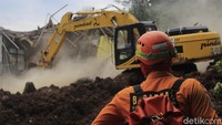 Guna memudahkan petugas untuk melakukan pencarian dan proses evakuasi, sebuah TK dan rumah yang berada lokasinya berada di muka puing-puing longsor pun dirobohkan. Yudha Maulana/Detikcom