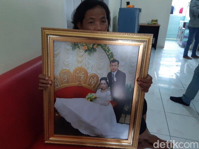 Yayu, asisten rumah tangga sambil menunjukan foto mendiang Arneta Fayzia bersama suaminya.
