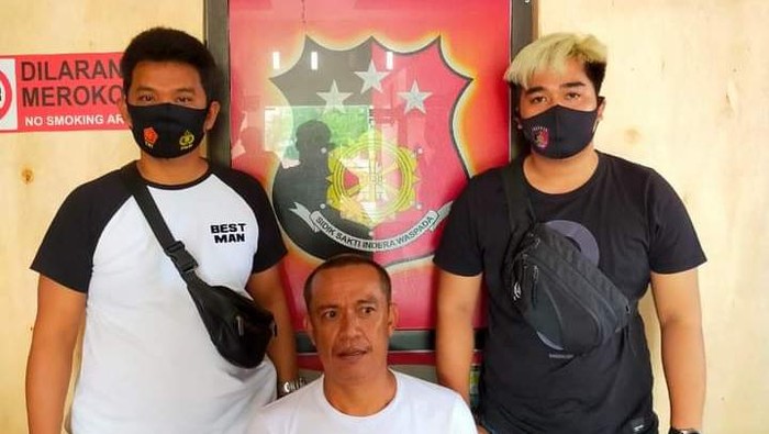 Aco (tengah) ditangkap polisi usai menipu seorang kurir agar membayar HP pesanannya (dok. Istimewa).