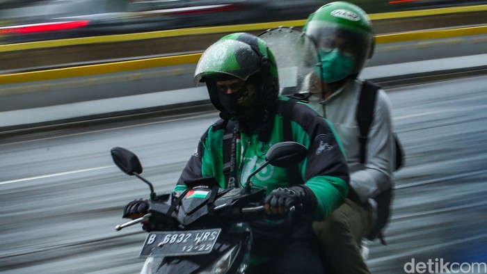 Pengendara ojek online melintas di jalan Sudirman, Jakarta, Selasa (12/1/2021). Pemberlakuan Pembatasan Kegiatan Masyarakat (PPKM) membuat orderan ojek online mulai sepi.