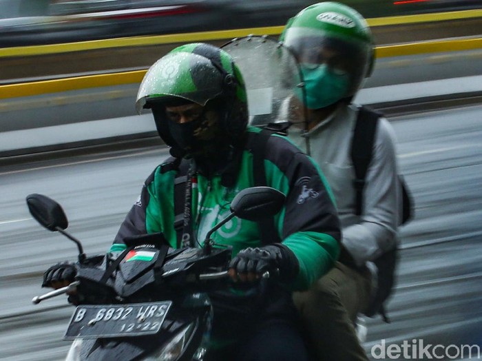 Pengendara ojek online melintas di jalan Sudirman, Jakarta, Selasa (12/1/2021). Pemberlakuan Pembatasan Kegiatan Masyarakat (PPKM) membuat orderan ojek online mulai sepi.