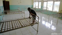 Relawan menyiapkan tempat tidur untuk pasien yang akan melakukan isolasi.