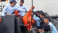 Serpihan yang dikumpulkan di dalam kantong dinaikkan ke atas kapal.
