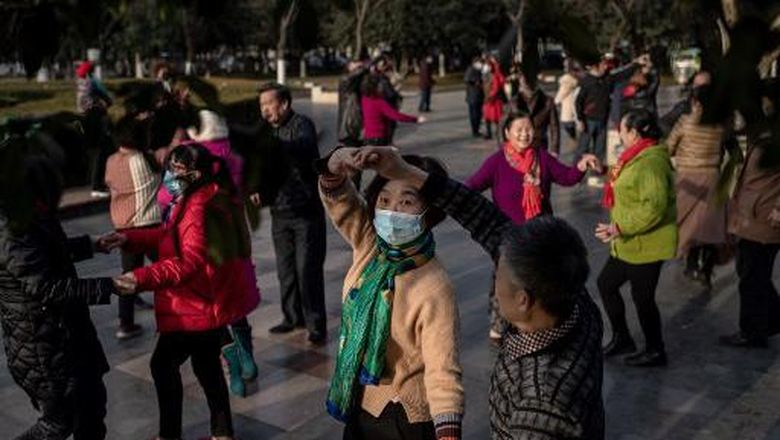 Elderly people dance in a public area along the Yangtze River in Wuhan on January 11, 2021, as the city marks the first anniversary of when China confirmed its first death from the COVID-19 coronavirus. (Photo by NICOLAS ASFOURI / AFP)
