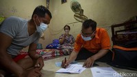 Petugas Pos Indonesia membagikan uang Bantuan Sosial Tunai (BST) di  kawasan Karanganyar, Jakarta, Rabu (13/1/2021).