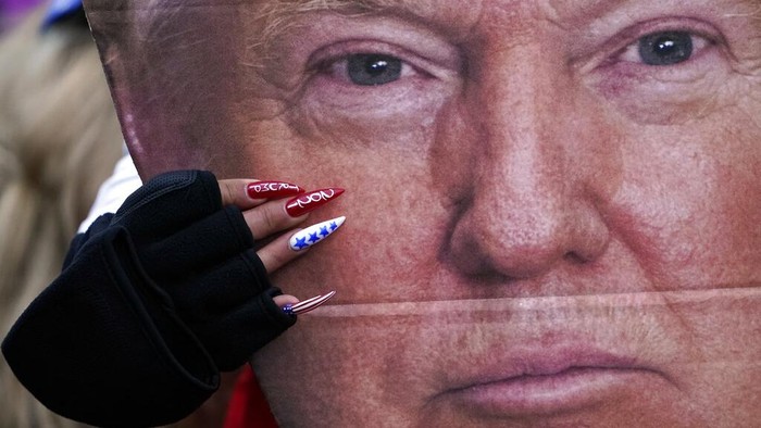 A woman holds a cut out of President Donald Trumps face Wednesday, Jan. 6, 2021, in Washington, at a rally in support of President Donald Trump called the Save America Rally. (AP Photo/Jacquelyn Martin)