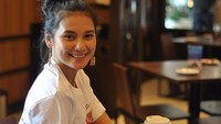 Nah, kalau yang satu ini adalah momen ngopinya di sebuah kafe. Tatanan rambut yang disanggul cocok untuk untuk Indah hanya mengenakan kaos simpel berwarna putih. Foto: Instagram @indahpermatas
