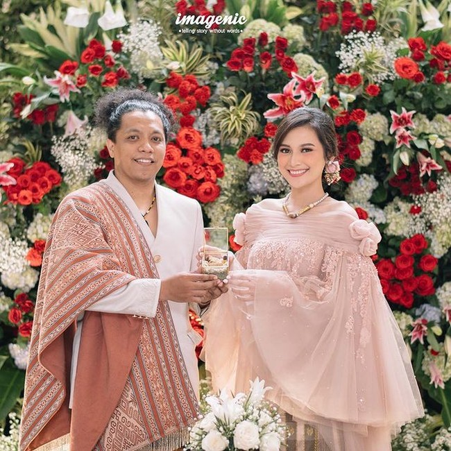 Indah Permatasari menikah dengan Arie Kriting mengenakan busana pengantin bergaya etnik yang diberi twist modern rancangan Didiet Maulana. Desain busana pengantin terinspirasi dari siluet baju bodo dengan potongan lengan oversize, yang dipadukan kain sutera dari Sengkang khas Makassar. Foto: dok. Imagenic