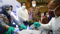 Mensos Tri Rismaharini bersama Direktur Hubungan Kelembagaan Bank Mandiri Rohan Hafas tampak memantau pembuatan kartu peserta program ATENSI di Jakarta.