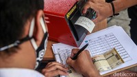 Warga mengambil hasil uji emisi kendaraanya.