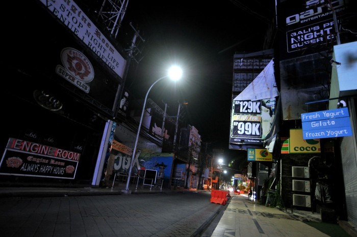 Suasana kawasan wisata Jalan Legian tampak sepi saat penerapan Pemberlakuan Pembatasan Kegiatan Masyarakat (PPKM) di Kuta, Badung, Bali, Selasa (12/1/2021). Seluruh kegiatan usaha di kawasan tersebut dibatasi operasionalnya hingga pukul 21.00 WITA saat penerapan kebijakan PPKM sebagai upaya untuk menekan penyebaran COVID-19. ANTARA FOTO/Fikri Yusuf/rwa.
