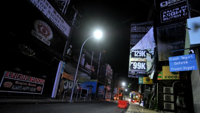Suasana kawasan wisata Jalan Legian tampak sepi saat penerapan Pemberlakuan Pembatasan Kegiatan Masyarakat (PPKM) di Kuta, Badung, Bali, Selasa (12/1/2021). Seluruh kegiatan usaha di kawasan tersebut dibatasi operasionalnya hingga pukul 21.00 WITA saat penerapan kebijakan PPKM sebagai upaya untuk menekan penyebaran COVID-19. ANTARA FOTO/Fikri Yusuf/rwa.