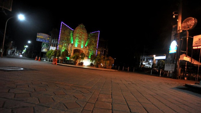 Suasana kawasan wisata Jalan Legian tampak sepi saat penerapan Pemberlakuan Pembatasan Kegiatan Masyarakat (PPKM) di Kuta, Badung, Bali, Selasa (12/1/2021). Seluruh kegiatan usaha di kawasan tersebut dibatasi operasionalnya hingga pukul 21.00 WITA saat penerapan kebijakan PPKM sebagai upaya untuk menekan penyebaran COVID-19. ANTARA FOTO/Fikri Yusuf/rwa.