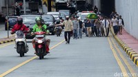 Selain memanggul keranda jenazah, sejumlah warga lain tampak bertugas untuk mengatur lalu lintas saat melintasi jalan raya menuju ke area pemakaman.