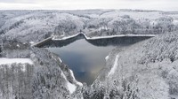 Pepohonan yang tertutup salju tercermin dalam air Oleftalsperre di Hellenthal, Jerman. Marcel Kusch/dpa via AP  