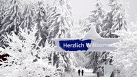 Orang-orang melewati papan bertuliskan Selamat Datang di Oberhof, Jerman. AP Photo/Matthias Schrader  