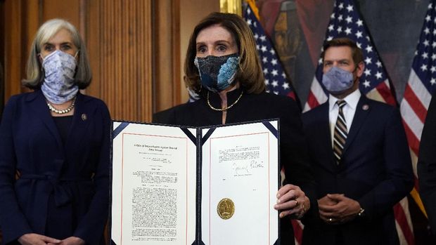 House Speaker Nancy Pelosi of Calif., displays the signed article of impeachment against President Donald Trump in an engrossment ceremony before transmission to the Senate for trial on Capitol Hill, in Washington, Wednesday, Jan. 13, 2021. (AP Photo/Alex Brandon)