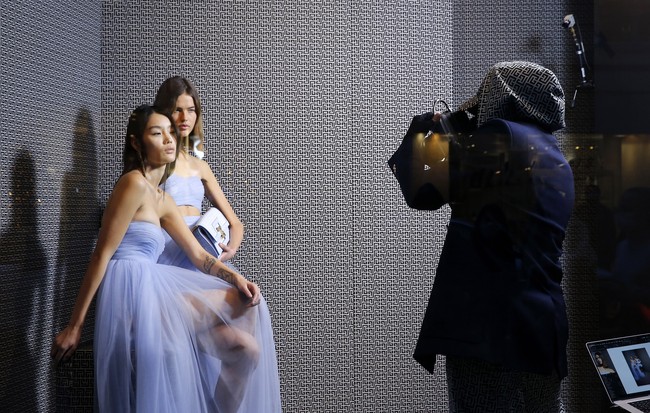 Desainer Balmain Olivier Rousteing melakukan pemotretan dari balik jendela butik Balmain di Paris dalam rangka peluncuran koleksi Pre Fall 2021. Foto: dok. Getty Images.