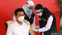 Dua petugas medis menyuntikkan vaksin Corona ke Wagub Emil. Dalam pemberian vaksin itu, tim medis maupun Emil wajib menerapkan protokol kesehatan seperti memakai masker.