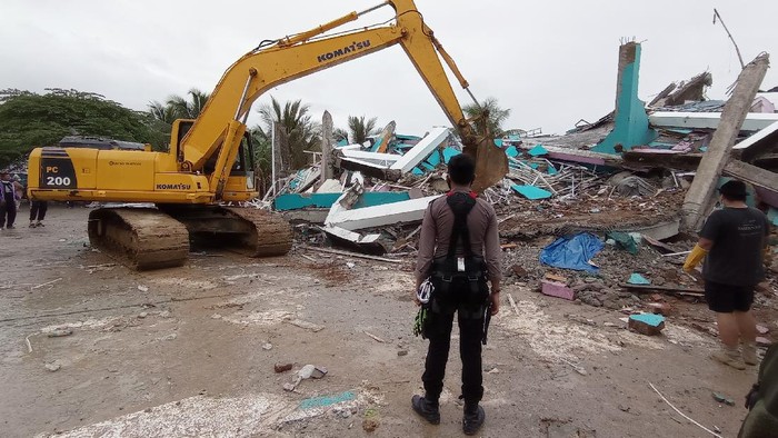 Petugas menggunakan alat berat memindahkan puing bangunan RS Mitra Manakarra yang rusak pascagempa bumi, di Mamuju, Sulawesi Barat, Jumat (15/1/2021). Petugas BPBD Sulawesi Barat masih mendata jumlah kerusakan dan korban akibat gempa bumi berkekuatan magnitudo 6,2 tersebut. ANTARA FOTO/Akbar Tado/wpa/hp.