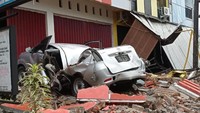 Sebuah mobil mengalami kerusakan sangat parah tertimpa puing-puing bangunan yang terjadi akibat gempa di Majene, Sulawesi Barat (ANTARA FOTO/AKBAR TADO)