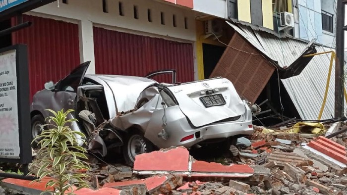 DAMPAK GEMPA SULAWESI BARAT Sebuah mobil dan bangunan rusak akibat gempa bumi, di Mamuju, Sulawesi Barat, Jumat (15/1/2021). Petugas BPBD Sulawesi Barat masih mendata jumlah kerusakan dan korban akibat gempa bumi berkekuatan magnitudo 6,2 tersebut. ANTARA FOTO/Akbar Tado/wpa/hp.