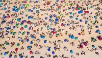 Pemandangan udara dari orang-orang yang menikmati cuaca di Pantai Ipanema di Rio de Janeiro, Brasil. Getty Images/Buda Mendes  