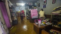 Warga merapikan barang di dalam rumahnya yang terendam banjir di Gang Pirus Tiga, Banjarmasin, Kalimantan Selatan, yang terendam banjir sejak Kamis (14/1/2021).
