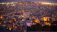 Seorang pria mengamati kota Barcelona, Spanyol. David Ramos/Getty Images  