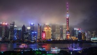 Kapal berlayar di Sungai Huangpu saat cakrawala kota terlihat di Shanghai, China. Kevin Frayer/Getty Images  