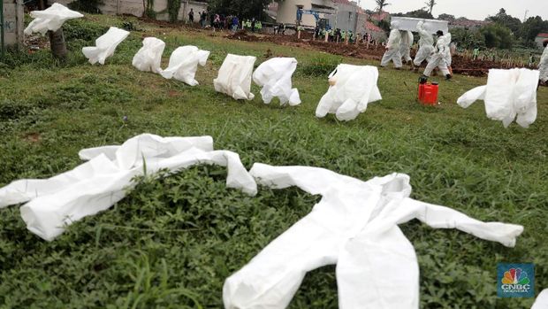 Petugas membawa peti jenazah yang akan dimakamkan dengan protokol COVID-19 di area khusus TPU Srengseng Sawah, Jakarta, Jumat (15/1/2021). TPU Srengseng Sawah mulai menerima pemakaman jenazah dengan protokol COVID-19 sejak Selasa (12/1) lalu. Menurut petugas makam dalam tiga hari terakhir sudah 164 jenazah Covid-19 yang dikubur di TPU tersebut. Lahan pemakaman di Pondok Rangon dan Tegal Alur yang saat ini menjadi lahan pemakaman pasien Corona Virus Desease 2019 (COVID-19) yang hampir penuh. Meski untuk jenazah pasien Covid 19, jenazah non Covid-19 masih bisa digunakan untuk pemakaman. Pantauan CNBC Indonesia sampai pukul 14.00 wib sudah 20 jenazah yang dimakamkan, dan kemungkinan akan bertambah lagi. Ada empat TPU di wilayah Jakarta yang digunakan untuk memakamkan jenazah pasien Covid-19, yakni TPU Tegal Alur di Jakarta Barat, TPU Pondok Ranggon di Jakarta Timur, TPU Rorotan di Jakarta Utara, dan TPU Srengseng Sawah. Dikutip dari CNN Indonesia pada Kamis, 14/1, Kepala Suku Dinas Pertamanan dan Hutan Kota Jakarta Selatan Winarto mengatakan, lahan di TPU Srengseng Sawah digunakan untuk memakamkan jenazah Covid-19 muslim. Dalam menangani krisis lahan pemakaman ini, pihak TPU Pondok Ranggon maupun TPU Tegal Alur juga menerapkan makam tumpang. Namun, mekanisme tersebut harus mendapat izin pihak keluarga. (CNBC Indonesia/ Muhammad Sabki)