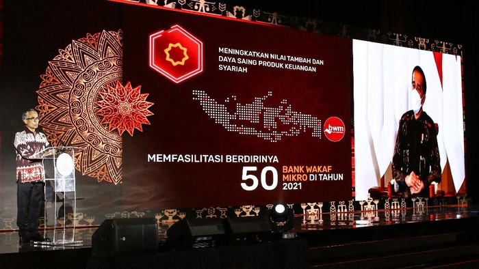 Ketua Dewan Komisioner OJK Wimboh Santoso (kiri) memberikan sambutan yang disaksikan secara virtual oleh Presiden Joko Widodo (kanan) saat pertemuan tahunan OJK di Jakarta, Jumat (15/1/2021). OJK sudah menyiapkan berbagai kebijakan stimulus lanjutan untuk tetap menjaga industri jasa keuangan dan meningkatkan kontribusinya dalam mendorong serta memulihkan perekonomian nasional yang termuat dalam Masterplan Sektor Jasa Keuangan Indonesia (MPSJKI) 2021  2025. ANTARA FOTO/Rivan Awal Lingga/foc.
