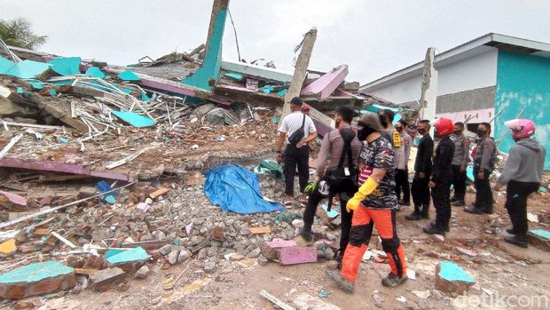 Warga mengamati Gedung Kantor Gubernur Sulawesi Barat yang rusak akibat gempa bumi, di Mamuju, Sulawesi Barat, Jumat (15/1/2021). Petugas BPBD SUlawesi Barat masih mendata jumlah kerusakan dan korban akibat gempa bumi berkekuatan magnitudo 6,2 tersebut. ANTARA FOTO/Akbar Tado/wpa/hp.