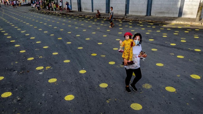 Jalanan di Manila Mendadak Polkadot MANILA, PHILIPPINES - JANUARY 16: Police officers wielding truncheons walk over social distancing markers on the road as part of preparations for masses a day before the Feast of Santo Nino (Baby Jesus) on January 16, 2021 in Manila, Philippines. Authorities have prohibited most festivities in celebration of the Feast of Santo Nino but have allowed physical masses despite worries that the event could help spread the coronavirus disease. (Photo by Ezra Acayan/Getty Images)