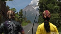 Warga tampak mengamati aktivitas Gunung Merapi yang mengeluarkan asap sulfatara di kawasan Sleman, Yogyakarta, Minggu (17/1/2021).
