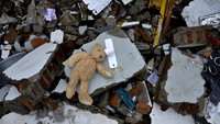 Sebuah mainan boneka berada di sekitar reruntuhan rumah yang rusak akibat gempa bumi di Kabupaten Mamuju, Sulawesi Barat, Minggu (17/1/2021).