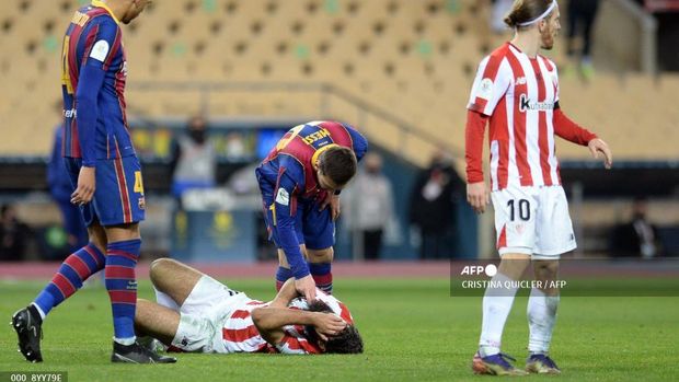 FBL-ESP-SUPER CUP-BARCELONA-ATHLETIC Barcelona's Argentinian forward Lionel Messi checks on Athletic Bilbao's Spanish forward Asier Villalibre (BOTTOM) during the Spanish Super Cup final football match between FC Barcelona and Athletic Club Bilbao at La Cartuja stadium in Seville on January 17, 2021. (Photo by CRISTINA QUICLER / AFP)