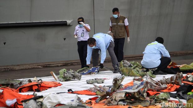 Petugas KNKT memeriksa puing pesawat SJ-182 di kawasan Posko Darurat Sriwijaya Air, JICT, Jakarta Utara, Senin (18/1).