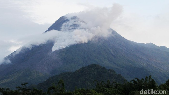 Warga mengamati Gunung Merapi yang mengeluarkan awan panas di Wonorejo, Hargobinangun, Pakem, Sleman, D.I Yogyakarta, Senin (18/1/2021). BPPTKG D.I Yogyakarta mencatat pada periode pengamatan Senin (18/1) pukul 00:00-06:00 WIB secara visual, Gunung Merapi mengeluarkan awan panas sebanyak satu kali dengan jarak luncur 1.000 meter, tinggi kolom 50 meter ke Tenggara arah Barat Daya serta guguran lava pijar sebanyak enam kali dengan jarak luncur maksimum 600 meter ke Barat Daya.