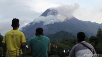Warga mengamati Gunung Merapi yang mengeluarkan awan panas di Wonorejo, Hargobinangun, Pakem, Sleman, D.I Yogyakarta, Senin (18/1/2021).