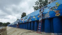 Dinding turap itu dipercantik oleh Komunitas Mural Depok.
