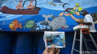Para seniman itu membuat mural untuk mempercantik bantaran Sungai Ciliwung.