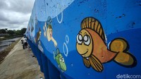 Kini dinding turap terlihat lebih cantik dengan adanya mural tersebut.