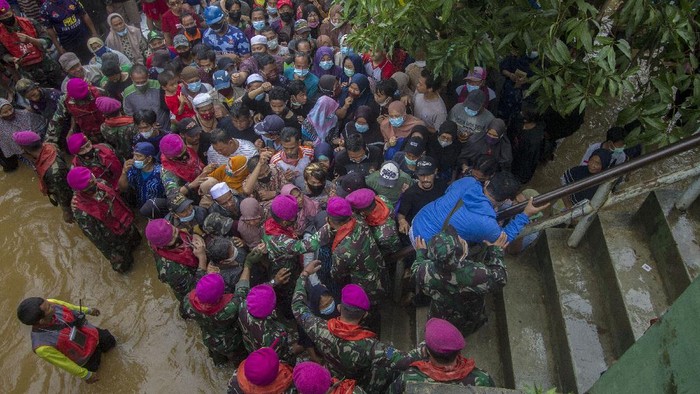 Petugas membagikan paket bantuan sembako Presiden Joko Widodo kepada warga di Desa Pekauman Ulu, Kabupaten Banjar, Kalimantan Selatan, Senin (18/1/2021). Paket bantuan tersebut dibagikan langsung kepada warga yang menjadi korban banjir saat presiden meninjau bencana di Kalimantan Selatan tersebut. ANTARA FOTO/Bayu Pratama S/aww.
