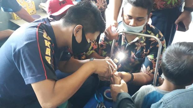 Petugas Damkar Sragen berusaha melepas cincin dari jari warga yang membutuhkan bantuan.