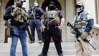 Anggota Boogaloo , yang memegang senjata semi-otomatis berdiri di luar gedung Capitol di Frankfort, Rabu  17 Jan 2021. Capitol, kompleks Capitol, dan area sekitarnya telah ditutup. JEFF KOWALSKY / AFP