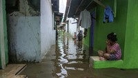 Warga duduk di depan rumahnya yang terendam banjir di Sampangan, Pekalongan, Jawa Tengah, Selasa (19/1/2021). ANTARA FOTO/Harviyan Perdana Putra