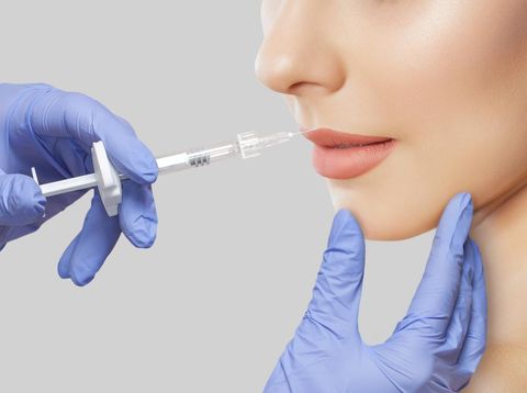 Cosmetologist does anti wrinkle injections on the chin, lips and on the face of a beautiful woman in a beauty salon. Cosmetology concept.Cosmetologist does anti wrinkle injections on the chin, lips and on the face of a beautiful woman in a beauty salon. Cosmetology concept.